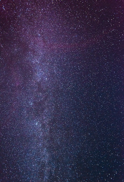 Stunning starry sky on a cloudless winter night amid a bluepink fog glows above the Earth