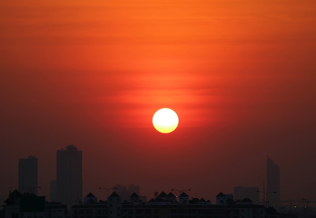 シルエットの高い建物、バンコク、タイの上の深いオレンジ色の空に見事な夕日