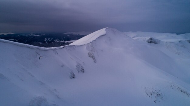 Stunning view of the cliffs covered with snow and trees on a cloudy winter day at the ski resort