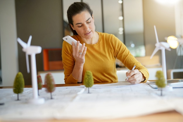 Photo stunning wind turbine engineer with cellphone planning wind farm placement