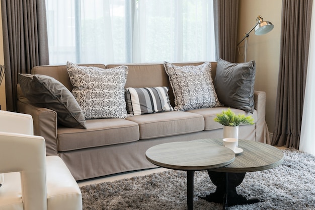 Прочный коричневый твидовый диван с серыми узорчатыми подушками