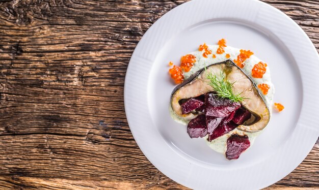 Filetto di storione con barbabietola da caviale e aneto su piastra in hotel o ristorante.