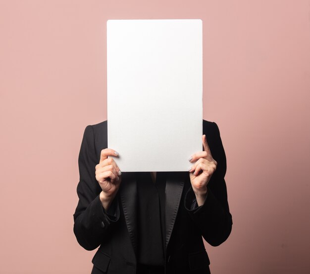 Style blonde in blazer and sunglasses with paper on pink background