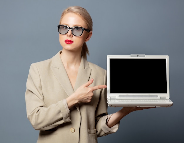 Photo style blonde with laptop computer on gray space