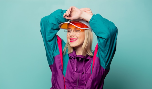 Style blonde woman in 80s glasses and hat