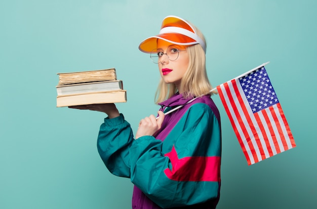 Stile donna bionda in abito sportivo anni '90 con libri e bandiera usa