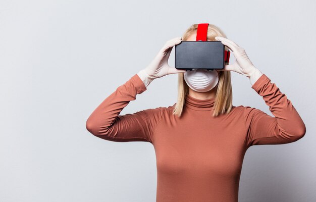 Style blonde woman in face mask with VR glasses