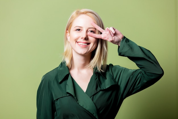 Style blonde woman in green gloak