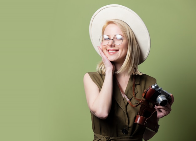 Style blonde woman in hat with camera