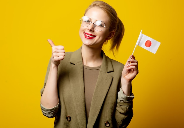 Style blonde woman in jacket with japanese flag on yellow