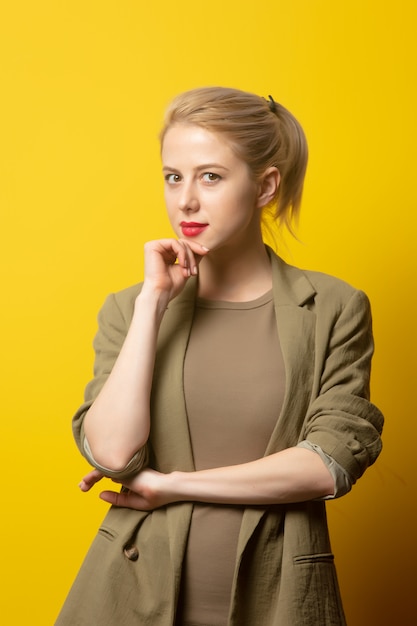 Style blonde woman in jacket on yellow