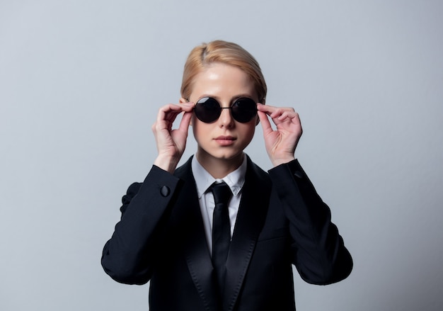 Style businesswoman in a classic black business suit and sunglasses