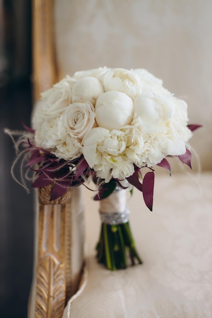 Style floral arranging wedding concept young woman dressed in extremely beautiful snowy white dress with puffy skirt is holding great bunch of different flowers stretched with yellow ribbons