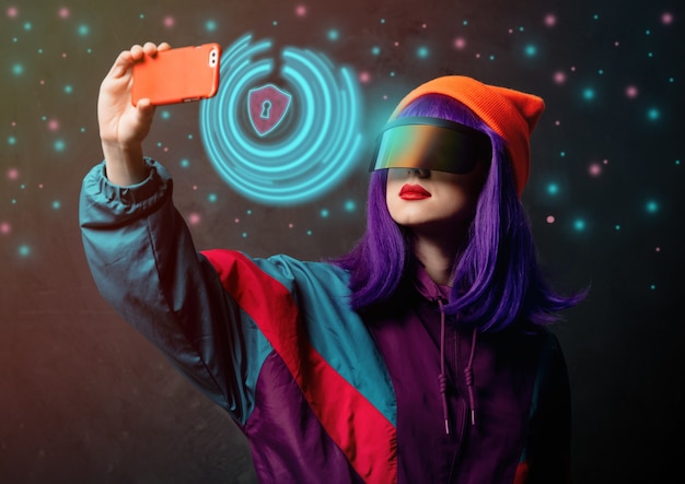 Style hacker woman in VR glasses is with mobile phone