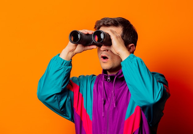 Style man in 80s tracksuit with binoculars