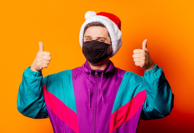 Style man in face mask and 80s tracksuit with Christmas hat