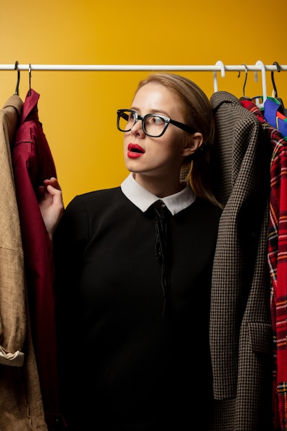 Style woman in black formal dress with clothes on rail
hanger