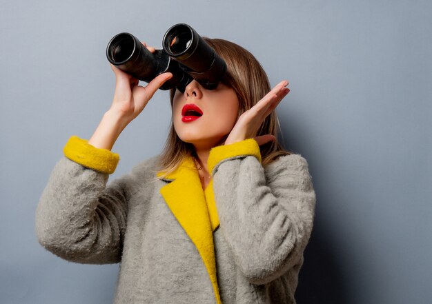 Style woman in coat with binoculars 