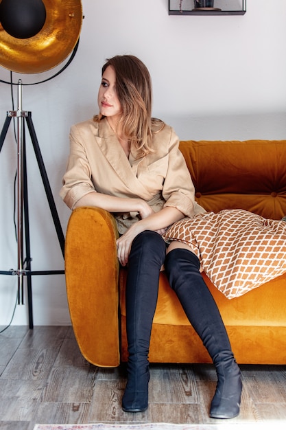 Style woman with makeup sitting in sofa