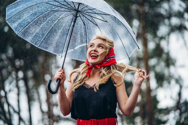 雨の日に傘をさしたスタイルのブロンド