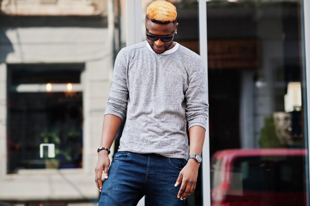 Photo stylish african american boy on gray sweater and black sunglasses posed at street fashionable black guy