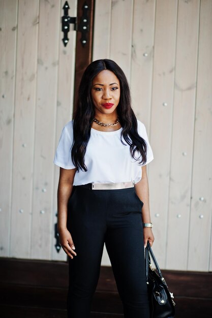 Stylish african american business woman with handbag on streets of city