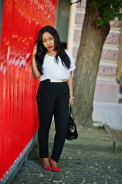 Stylish african american business woman with handbag on streets of city