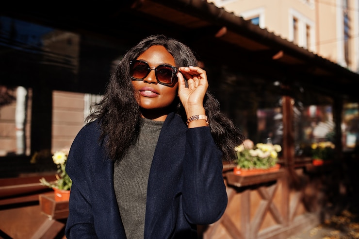 Photo stylish african american girl in blue coat and sunglasses posed at sunny autumn day. africa model woman.