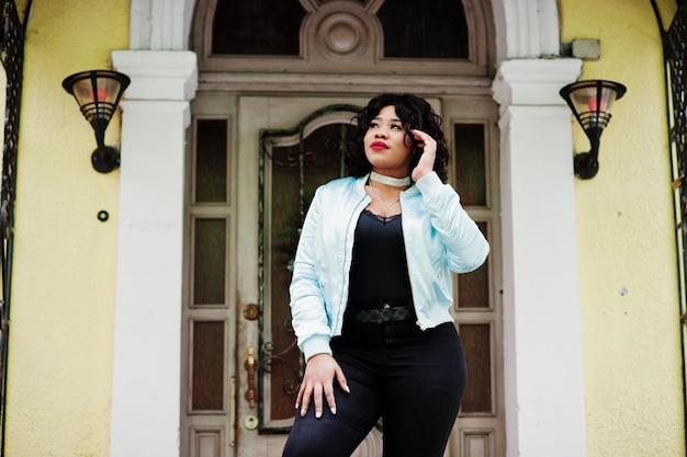 Stylish african american plus size model at streets of city against enter of house