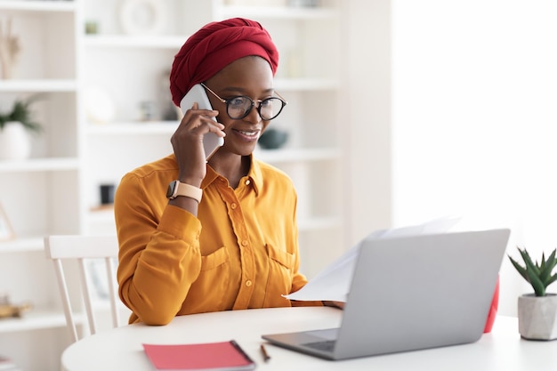 Stylish african american woman in turban working from home