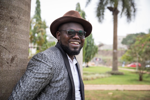Stylish african businessman looks smilingly around in the park Outdoor concept