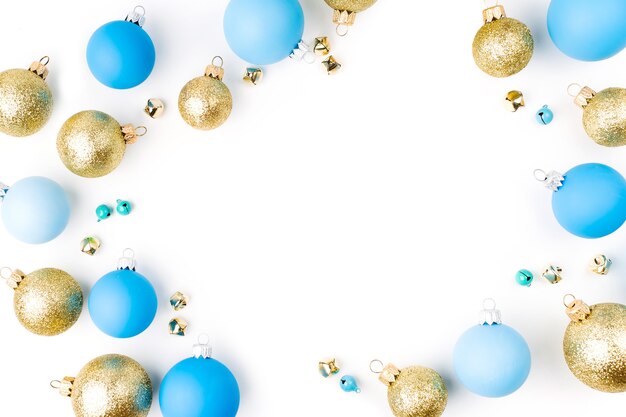 Stylish arrangement, frame of blue and gold christmas balls on white background. Flat lay, top view