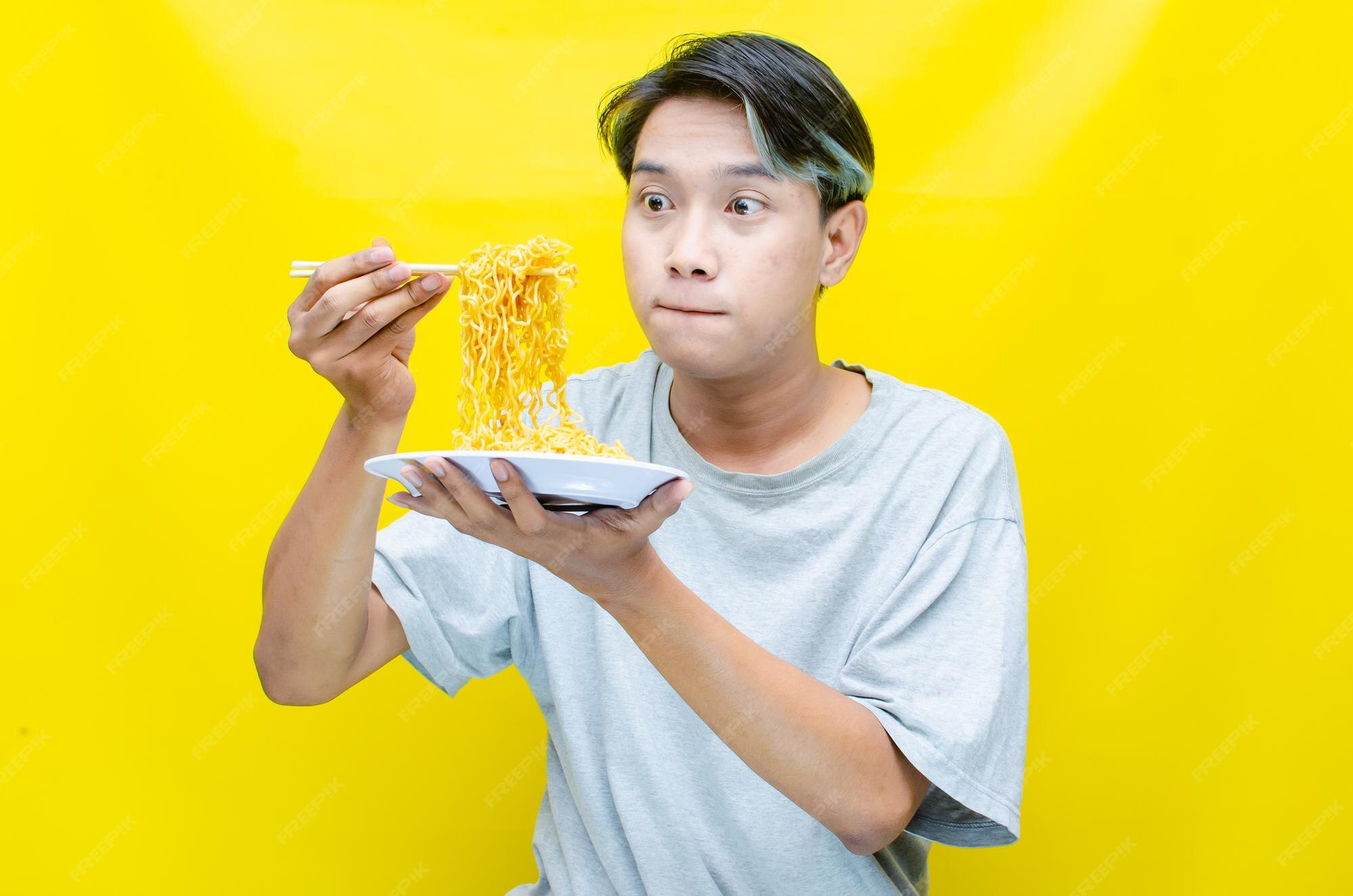 Premium Photo | Stylish asian man with peek a boo hair eats instant noodle