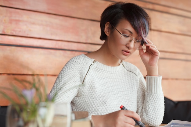 Stylish Asian woman writing