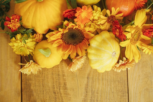 Foto elegante composizione autunnale fiori colorati zucche zucche su legno rustico happy thanksgiving