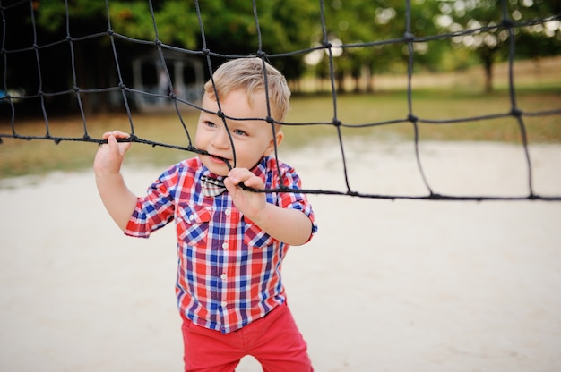 Stylish baby boy hanging volleyball net