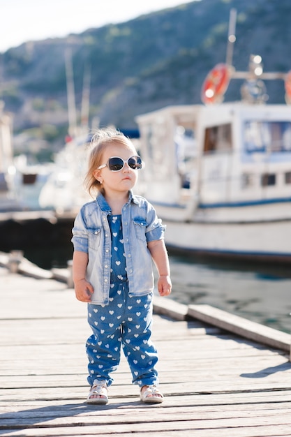 Stylish baby girl wearing denim clothes outdoors