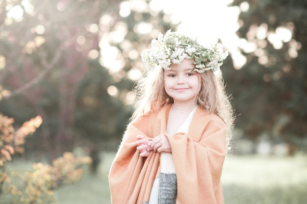 Stylish baby girl wearing trendy poncho outdoors