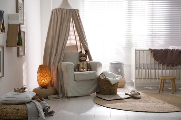 Foto elegante baby room interna con culla e comoda poltrona