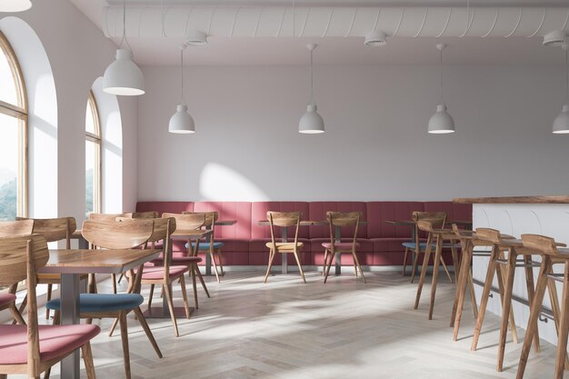 Stylish bar interior with white walls, a concrete floor, original windows, dark pink sofas, round tables and wooden chairs. 3d rendering mock up