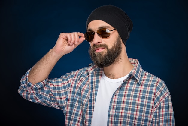 Stylish bearded man in a cap and glasses.