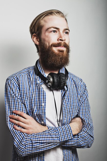 Stylish bearded man in  shirt. Close up portrait over grey background.