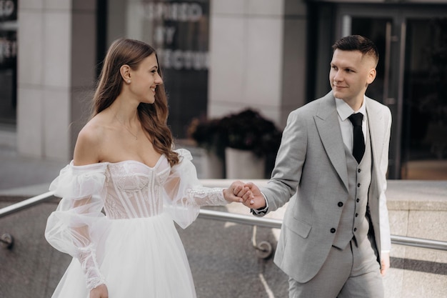 Stylish beautiful couple European newlyweds walking on the city