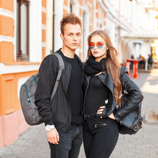 Stylish beautiful couple in trendy clothes with bags traveling together