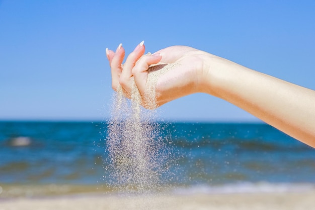 Stylish beautiful hands sypyat sand sea summer on the nature