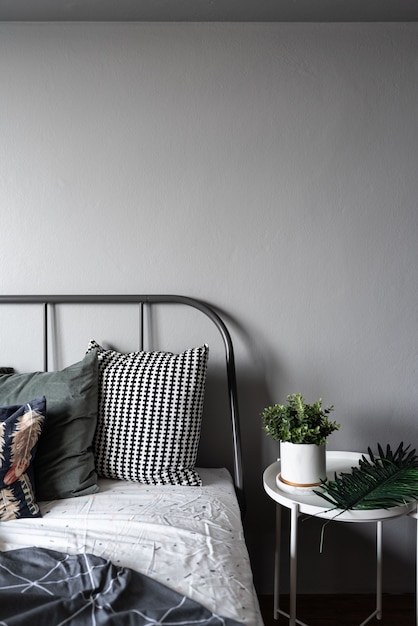 Photo stylish bedroom corner with artificial plants in white ceramic vase