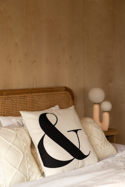 Foto elegante angolo della camera da letto con testiera in rattan e soffice cuscino decorato