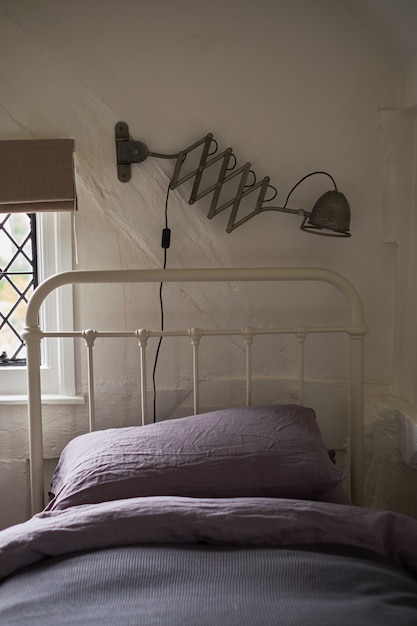 Photo stylish bedroom design with dark pillows on the bed and a decorative black lamp.