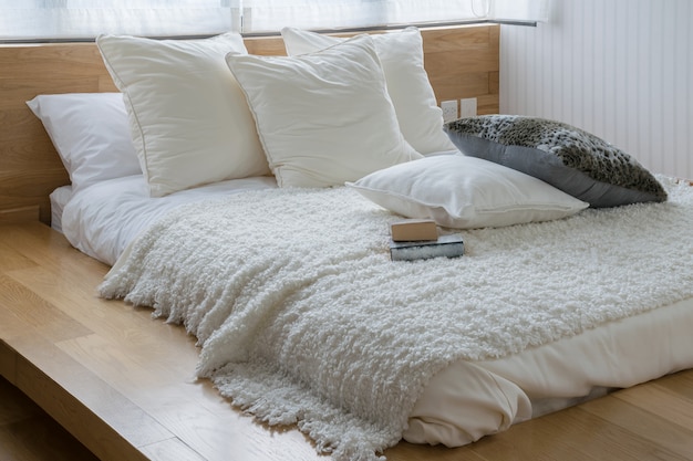 Stylish bedroom interior design with black and white pillows on bed.