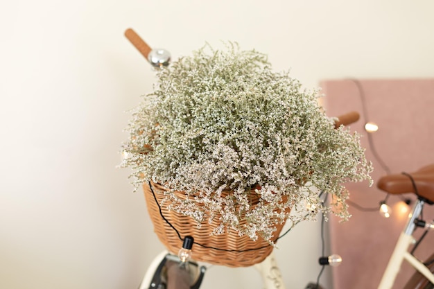 고리버들 바구니와 꽃이 있는 세련된 자전거. 식물과 꽃을 위한 장식용 자전거 거치대